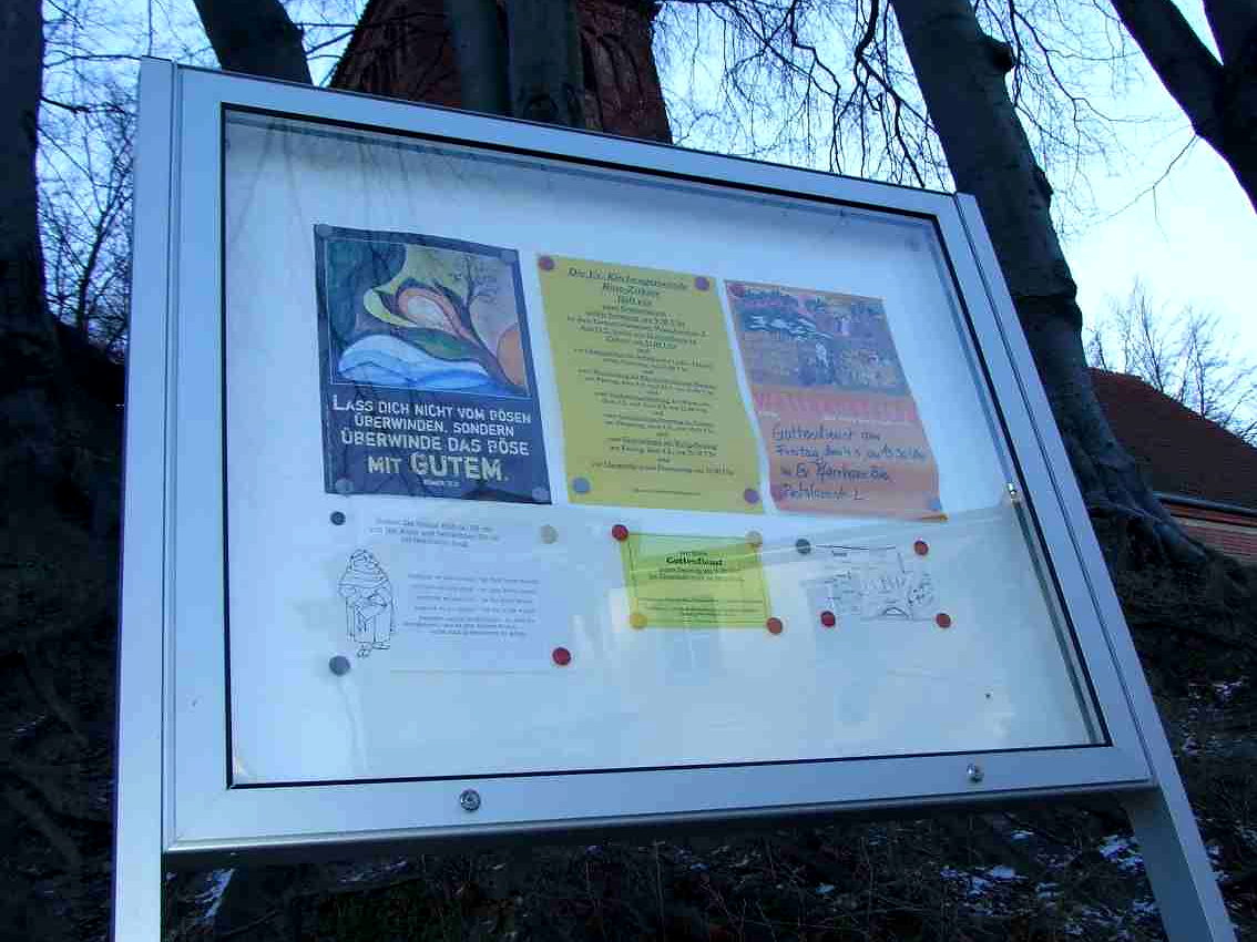 Freistehender Schaukasten mit Edelstahlrahmen und Sicherheitsglas, gefuellt mit Aushaengen einer Kirchengemeinde