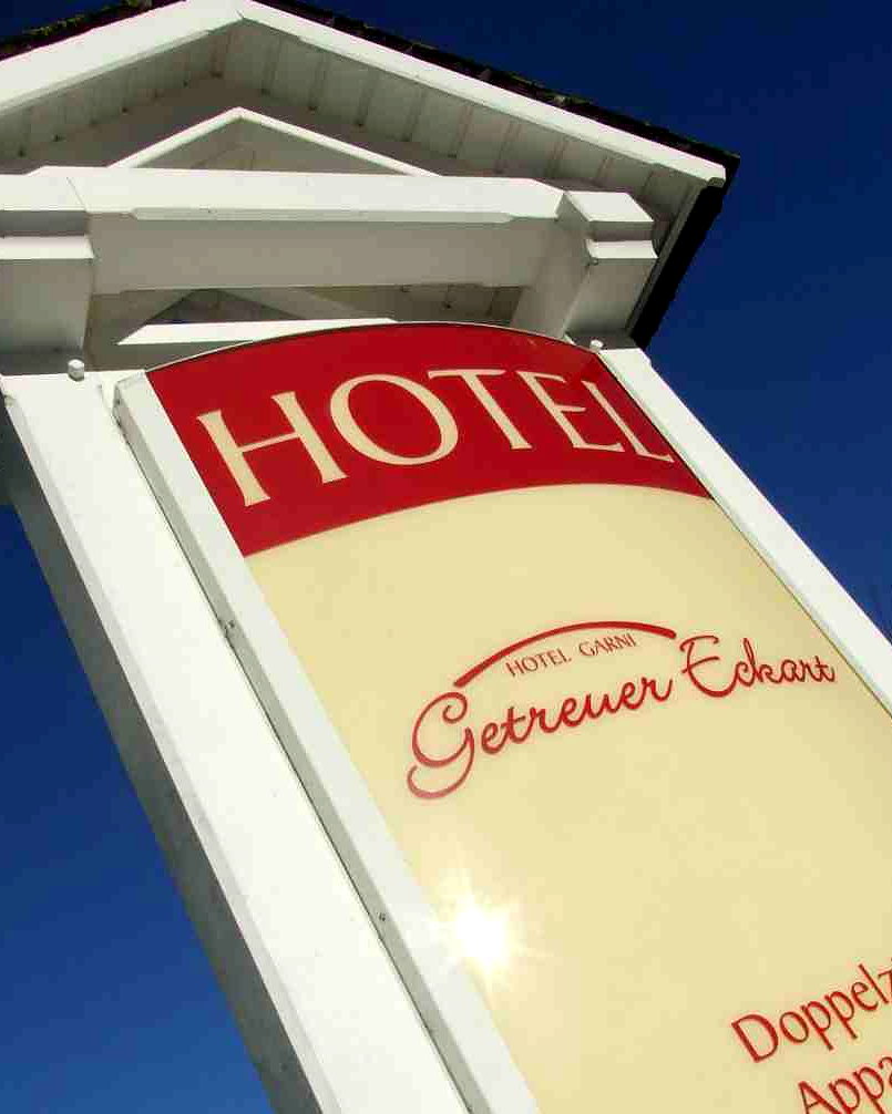 Auslegerschild des Hotel Garni Getreuer Eckart am weissen Mast vor blauem Himmel